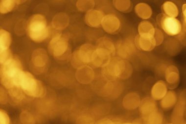 Yumuşak, bulanık ışık çemberleri ile altın bir bokeh efekti içeren büyüleyici soyut bir arka plan hayal ürünü ve zarif bir atmosfer yaratıyor, herhangi bir yaratıcılığa biraz sihir katmak için mükemmel.