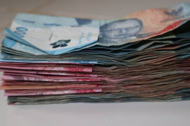 Endonezya 'nın önemli miktarda Rupiah banknotunun sergilendiği, finansal refahı ve para kaynaklarını temsil eden yakın plan bir çekim.