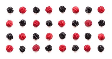 Beyaz arka planda taze ahududu ve böğürtlenlerin renkli düzenlemeleri doğal güzellikleri ve canlı renkleri sergiliyor.