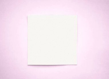 Yaratıcılık için minimalist tasarım unsurlarını gösteren yumuşak pembe arka plan üzerinde dinlenen boş beyaz kare kağıt yaprağı