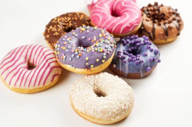 Sekiz donuttan oluşan canlı bir seçimde çeşitli renkler ve malzemeler sergileniyor, serpiştirme, krema ve hindistan cevizi de dahil. Her tatlı olay için ideal..