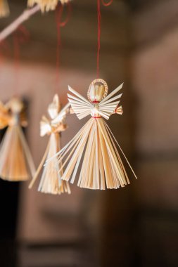 Hassas saman melekleri iplerden sarkıtılıyor, karmaşık tasarımlar sergiliyorlar. Sıcak ortam zanaatkarlıklarını ön plana çıkarıyor ve mevsimlik dekorasyonlara şenlikli bir dokunuş katıyor..