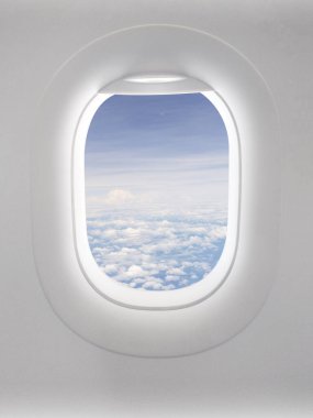 Bir uçak penceresinden büyüleyici bir manzara pofuduk bulutlardan oluşan bir panorama ve uçsuz bucaksız bir mavi gökyüzü. Seyahat ve yeni başlangıçlar için görsel bir metafor.