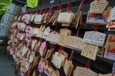 Ahşap tablet koleksiyonu geleneksel bir tapınakta asılı, duaları, dilekleri ve adakları temsil ediyor. Yakından bakınca eşsiz ahşap dokular sergileniyor..