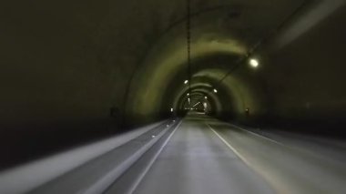 Japonya 'nın Nagano şehrinde aydınlatılmış pasaj: Bir tünelin içinde çarpıcı bir perspektif, simetrik bir tasarım ve davetkar bir yolculuk sergiliyor. Uzun, düz yol yukarıdaki ışıklarla aydınlatılır..