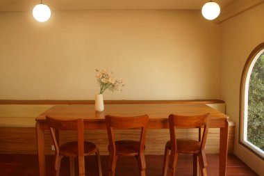 Modern bir ev içinde ahşap masası ve sandalyeleri olan rahat yemek odası.