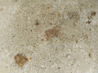 Yakın plan çekimde, eski ve dokulu bir yüzey ortaya çıkıyor. Erozyon belirtileri zamanı gösteriyor, elle tutulur bir deneyim sağlıyor..