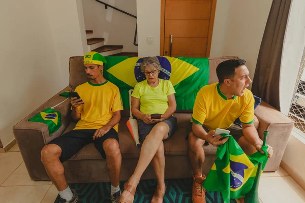 足球迷小组在客厅里观看足球比赛 庆祝世界杯的到来 为巴西成为冠军而欢呼的多民族家庭 — 图库照片