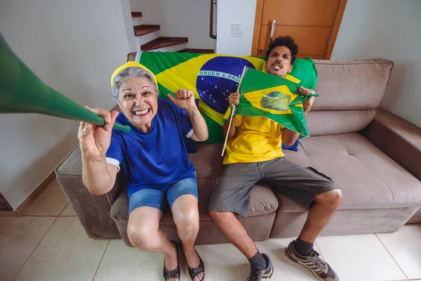 母子俩在客厅庆祝世界杯 为巴西看电视喝彩 混血儿家庭一边观看杯赛一边自拍 — 图库照片
