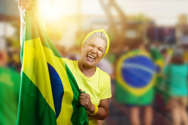 Senior Woman Holding Brazil Flag on Cinematic Background Written Towards Hex in Portuguese. For social media with copy space