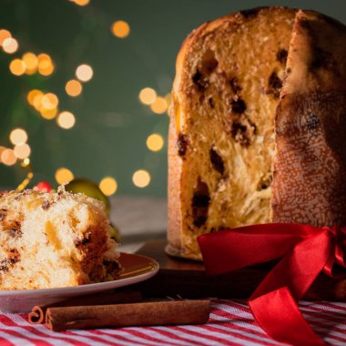 Noel için dekore edilmiş ahşap bir masada servis edilen meyveli ve çikolatalı kekler. Yeşil Arkaplanda Ev Yapımı Noel Ekmeği, Boşluğu Kopyala.