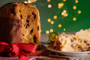 Noel için dekore edilmiş ahşap bir masada servis edilen meyveli ve çikolatalı kekler. Yeşil Arkaplanda Ev Yapımı Noel Ekmeği, Boşluğu Kopyala.