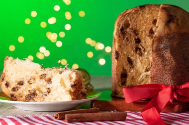 Noel için dekore edilmiş ahşap bir masada servis edilen meyveli ve çikolatalı kekler. Yeşil Arkaplanda Ev Yapımı Noel Ekmeği, Boşluğu Kopyala.