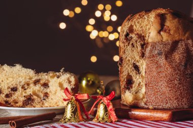 Noel için dekore edilmiş ahşap bir masada servis edilen meyveli ve çikolatalı kekler. Bulanık Arkaplanda Ev Yapımı Noel Ekmeği, Boşluğu Kopyala.