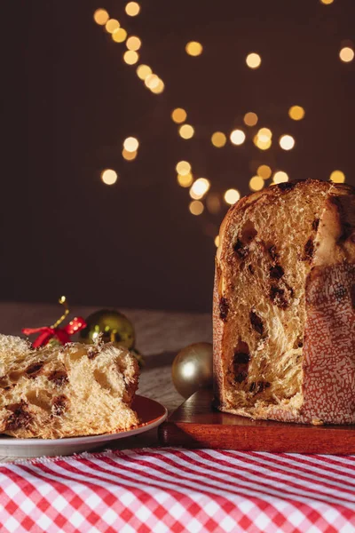 Noel için dekore edilmiş ahşap bir masada servis edilen meyveli ve çikolatalı kekler. Bulanık Arkaplanda Ev Yapımı Noel Ekmeği, Boşluğu Kopyala.