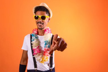 Carnival Outfit Party. Portrait of Black Man With Carnival Props Poiting,  Isolated on Orange Background