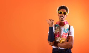 Carnival Brazilian Outfit. Black Man With Carnival Costume Pointing, Isolated on Orange Background