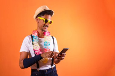 Carnival Brazilian Outfit. Black Man With Carnival Costume Holding Mobile,  Isolated on Orange Background