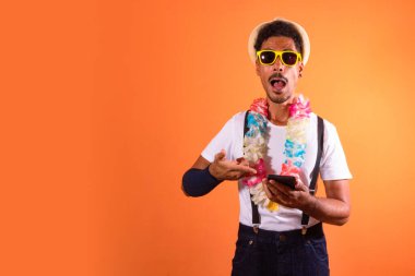 Carnival Brazilian Outfit. Black Man With Carnival Costume Holding Mobile,  Isolated on Orange Background