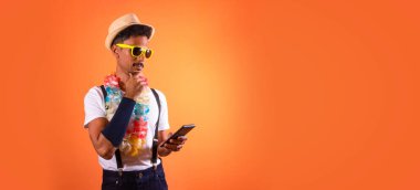 Carnival Brazilian Outfit. Black Man With Carnival Costume Holding Mobile,  Isolated on Orange Background