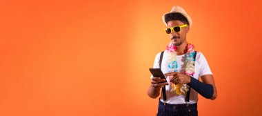 Carnival Brazilian Outfit. Black Man With Carnival Costume Holding Mobile,  Isolated on Orange Background