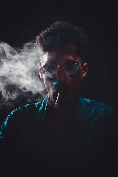 Preto Jovem Com Óculos Fumar Charuto Com Nevoeiro Fundo Preto — Fotografia de Stock