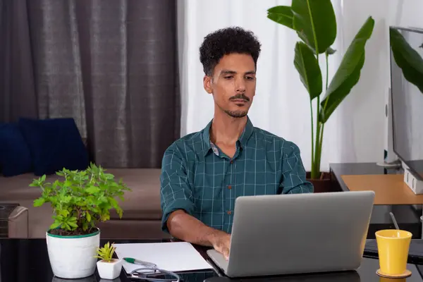 Black Man at Remote Job. Young Nomad on a Teleworking Meeting at Desk With Laptop