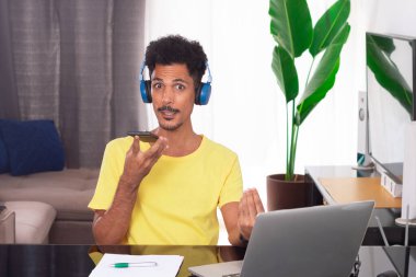 Uzak Görev 'de sarı tişört giyen siyah adam. Genç Dijital Göçebe Bilgisayarla Masa Başında Telesekreter Toplantısı