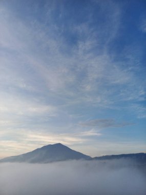 the view from the top of the hill is called the new panorama with a view of Mount Singgalang in the morning with a blue sky surrounded by clouds in Bukittinggi, West Sumatra clipart