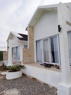 Ön planda görünen bir saksı bitkisi olan beyaz bir misafir evi Alahan Panjang, Batı Sumatra 'da..