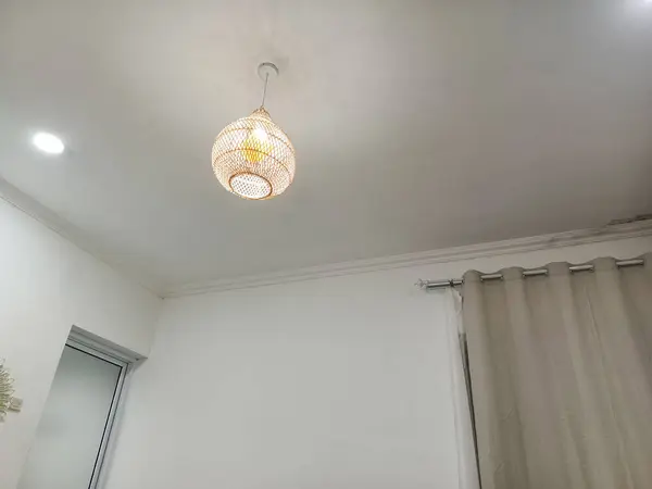 Dekoratif ışıklandırma tasarımı, perdeler ve banyo kapısı olan bir otel odası..