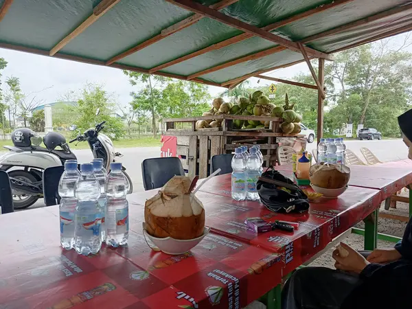 Pekanbaru, Endonezya - 27 Ocak 2025: Gündüz vakti açık bir alanda geleneksel hindistan cevizi standı.