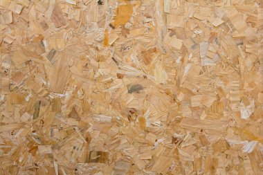 OSB tahtaları ahşap bir zemine zımparalanmış kahverengi odun parçalarından yapılmıştır. OSB tahta arkaplanının üst görünümü, dar yüzeyler