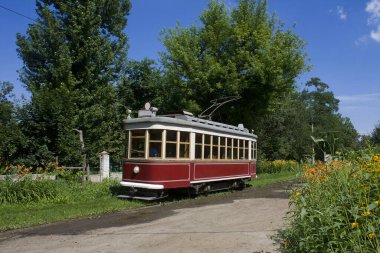 Ukrayna 'nın Kharkov kentindeki mavi gökyüzünün altında yeşillikler arasında eski güzel tramvay.