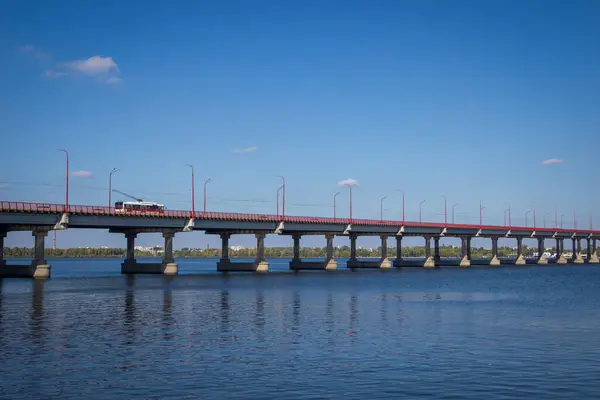 Ukrayna, Dnepr - 15 Ekim 2020 Dinyeper Nehri üzerindeki merkez köprü. Beyaz bir troleybüs köprüden geçiyor..