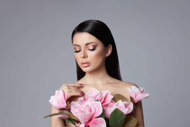 Bir kadının güzel portresi, pembe göz farı makyajı, oklar ve uzun kirpikleri. Esmer kadın, kırmızı oje, doğal kozmetik ürünleri.