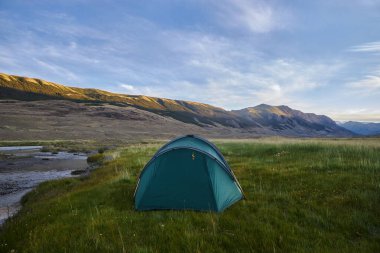 Dağlarda yürüyüş. Nehirler ve dağ gölleri, tepelerin ve tepelerin yaz manzarası. İnanılmaz bir yolculuk.