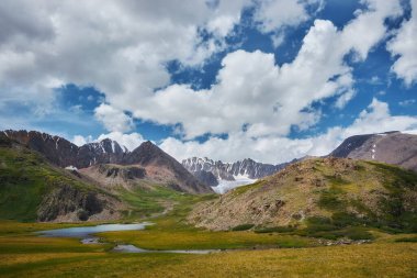 Dağ tepeleri, nehirler ve göllerden oluşan güzel bir manzara. Altai Dağları 'nın vahşi doğası. Dağların tepesindeki bulutlar. Rusya, Altai Cumhuriyeti