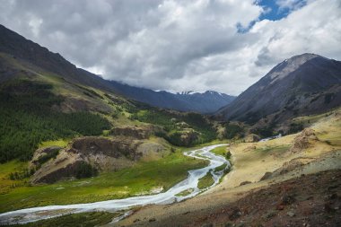 Dağ tepeleri, nehirler ve göllerden oluşan güzel bir manzara. Altai Dağları 'nın vahşi doğası. Dağların tepesindeki bulutlar. Rusya, Altai Cumhuriyeti