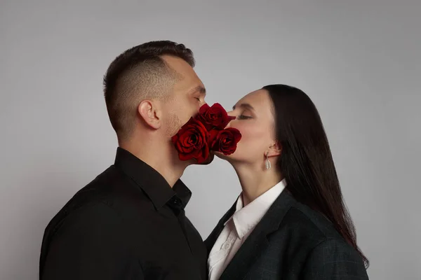 Couple in love kissing, lipstick marks on their face, a kiss. Rose flowers, love hugs. Man and woman husband and wife