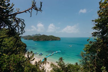 Çamurlu tekneleri olan sahil, yemyeşil ve berrak turkuaz sularla çevrili.
