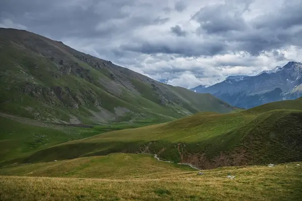 Céus Nublados Pairam Sobre Encostas Verdejantes Montanha Com Caminho Sinuoso Imagens Royalty-Free