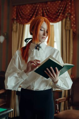 Retro Woman with red hair is engrossed in reading a book