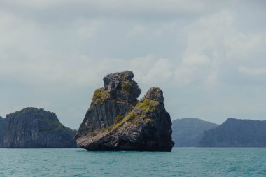Büyük kireçtaşı oluşumu okyanus suyundan yükselir, uzaktaki diğer adalar ve dağlarla birlikte..