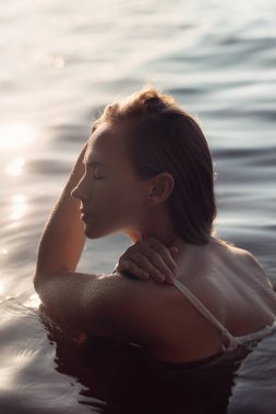 Kadınlar gün batımında sakin sulara dalmışken bir anlık huzurun tadını çıkarırlar. Işık su yüzeyine yansıyarak sakin bir atmosfer yaratarak dingin ifadesini arttırır..