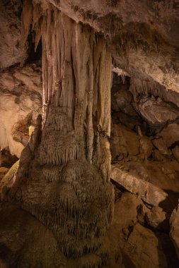 Yeraltındaki jeolojinin doğal güzelliğini vurgulayan, kireçtaşı bir mağarada yerden çarpıcı bir sarkıt oluşumu yükseliyor. İnce ışıklandırma karmaşık doku ve şekilleri geliştirir..