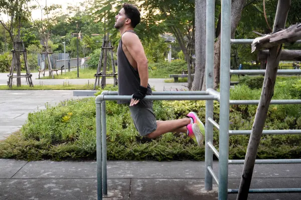 Bangkok, Tayland 'ın merkezindeki bir parkta jimnastik yapan genç bir adamın yan görüntüsü
