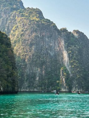 Jurassic-like landscape with majestic cliffs falling into the tropical waters after sunrise clipart