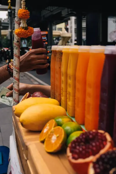 Bangkok, Tayland 'da bir seyyar satışta nakit para kazanan tanınmayan iki kişinin elleri. Turist plastik bir şişede nar suyu alıyor ve satıcı ona bozuk para veriyor.