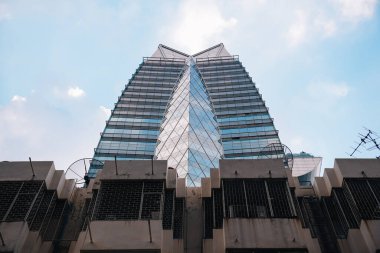 Bangkok 'un finans bölgesinde mavi gökyüzünün yansıması ile simetrik modern cam gökdelen; Tayland